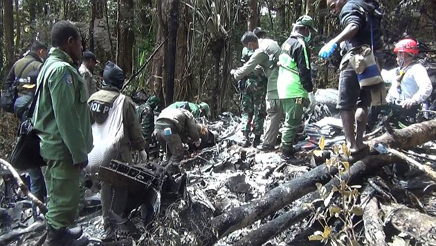 Indonesian rescuers search through wreckage of the Trigana Air ATR 42-300 twin-turboprop plane at the crash site in the mountainous area of Oksibil on August 18, 2015. A plane that crashed in eastern Indonesia was found on August 18 "completely destroyed" with the bodies of all 54 passengers and crew strewn amid the wreckage in a fire-blackened jungle clearing, officials said. AFP PHOTO